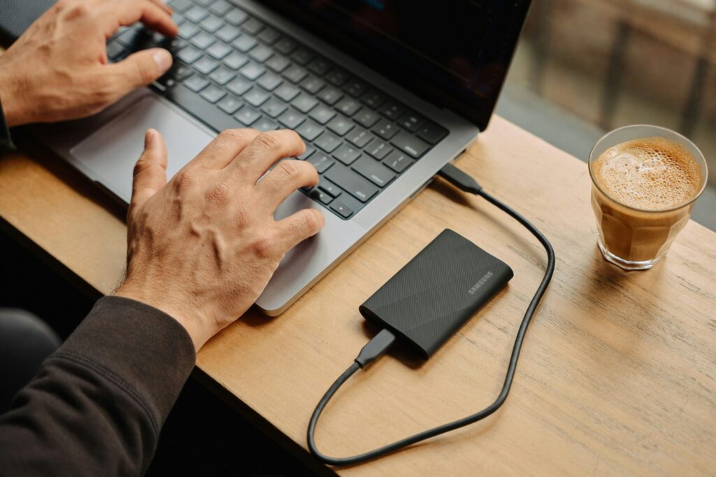 A man sitting at a table using a laptop computer